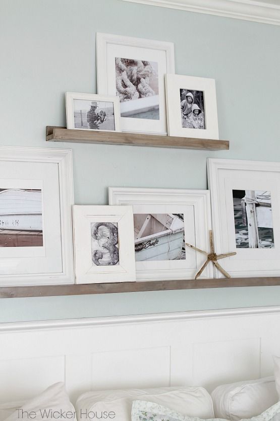 a coastal gallery wall with stained ledges and black and white photos in white frames is a lovely way to style a coastal home