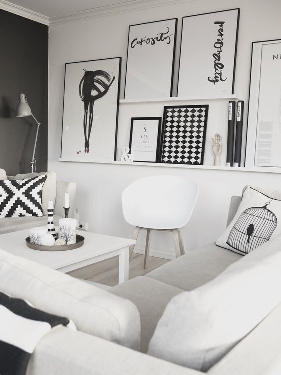 an oversized gallery wlal with white ledges and black and white oversized artwork is a bold statement for a black and white space