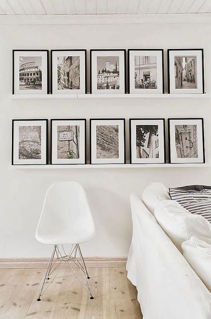 a gallery wall of white ledges and vintage-inspired black and white photos in black frames is a cool and stylish solution
