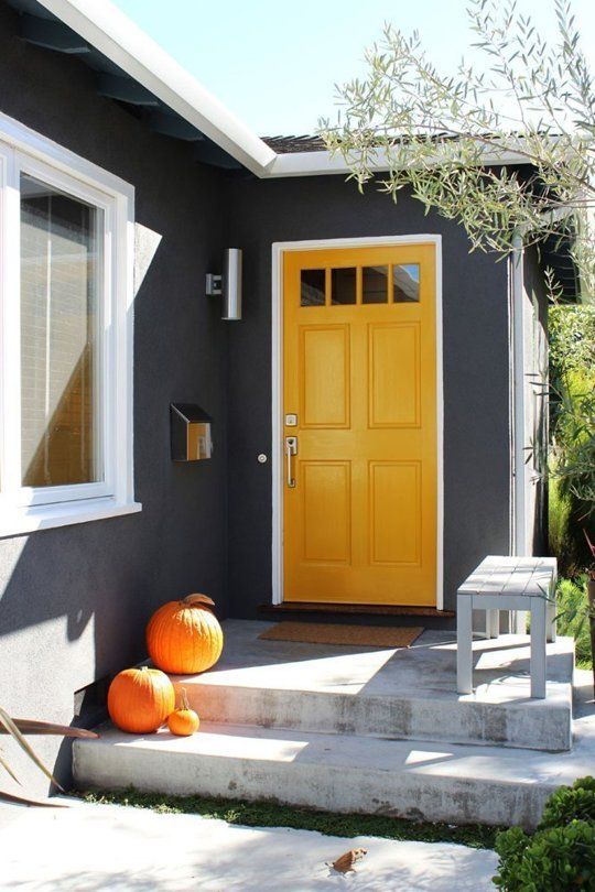 yellow front door in a black painted house