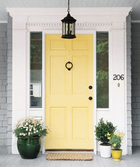 sunny yellow modern front door with yellow pots next to it