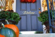 04 framing a door with corn stalks, a bold leaf wreath and nautral pumpkins