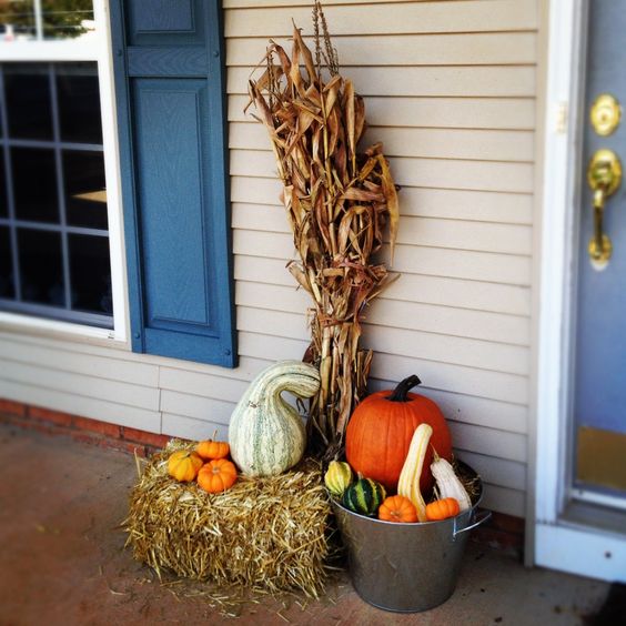 fall arrangement with pumpkins, gourds, hay and corn stalks