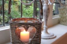 a basket turned into a candle holder is a cozy and cute idea for a rustic space, especially a vintage one