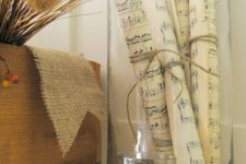 17 pages from old hymn books rolled and tied with twine and placed in a vase