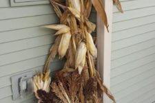 19 corn stalks, pumpkins, corn and hay in a bucket