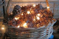 a basket with pinecones and lights is a great decoration for fall or winter, it’s a cozy display and you can DIY it