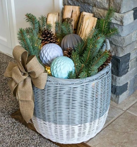 a basket with Christmas ornaments, firewood, evergreens and pinecones, LEDs inside is a gorgeous Christmas decoration