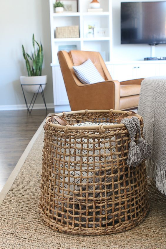 a basket with a pillow and a blanket is a cool solution for a rustic or farmhouse space, a nice storage idea