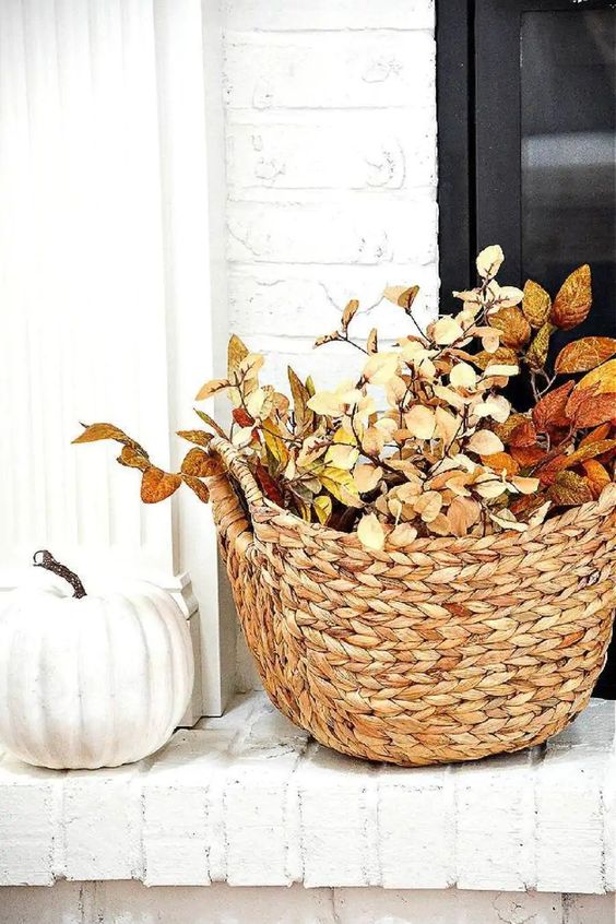 a basket with bright fall leaves and a faux pumpkin will be nice fall decorations, you can place them anywhere