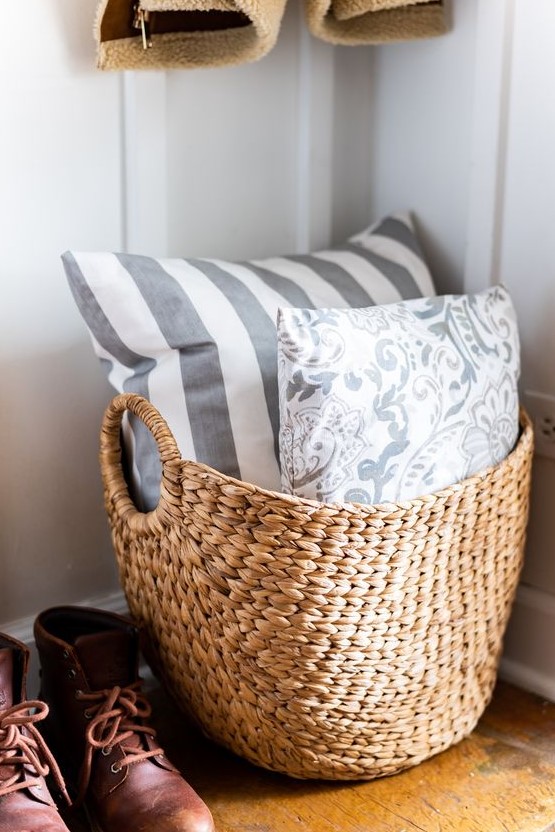 a basket with printed pillows is a nice addition to a living room or another space