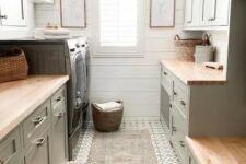 a dove grey farmhouse mudroom laundry with shaker kitchen cabinets, butcherblock countertops, a washing machine and a dryer and a printed rug