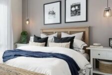 a modern farmhouse bedroom with a grey accent wall, a bed with a stained headboard, white nightstands and a woven basket chest