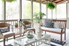 a modern screened patio with neutral seating furniture, a white coffee table, greenery and printed textiles