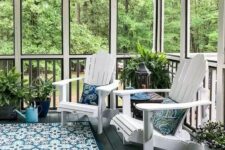a modern screened patio with white wooden chairs, a blue printed rug and pillows, lots of potted greenery and greenery around