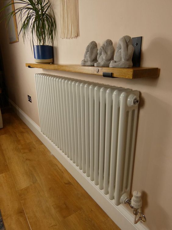 a small radiator with a stained shelf and decor on it are a lovely combo for any boho or modern space