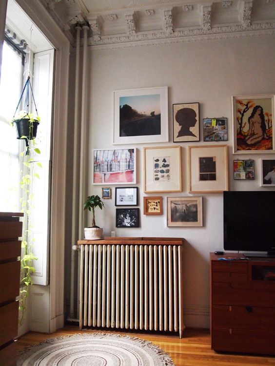 a small stained shelf installed over the radiator looks cohesive in the space and doesn't distract attention from the gallery wall