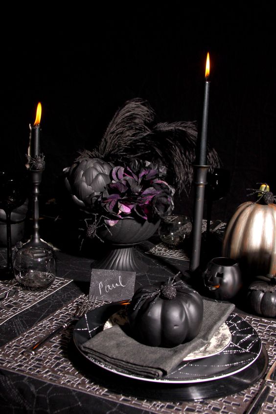 all black Halloween table decor with feathers and faux pumpkins