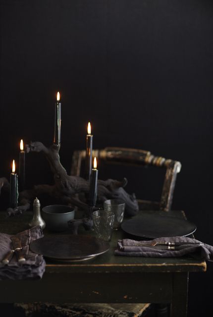 all black Halloween table decor with matte chargers and black candles