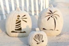 10 beach pumpkins carved with coastal motif and covered with sand