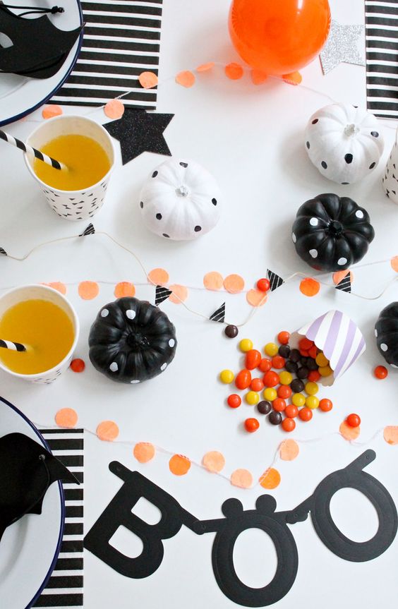 black and white party table with polka dot pumpkins and garlands