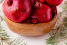 13 put pomegranates and cranberries in a wooden bowl for a centerpiece