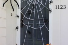 15 festive Halloween door decoration with a DIY giant spider web and spiders big and small crawling all over the door