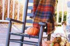 17 place a bold plaid blanket on a rocker to keep warmer while sitting outdoors