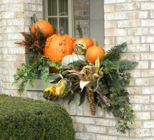 Outdoor window arrangements with faux vegetables and leaves