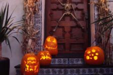 22 skeleton door decor and carved pumpkins on the stairs