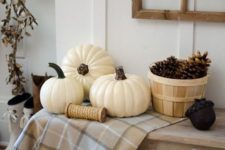 24 create a fall display with a neutral plaid blanket and pumpkins