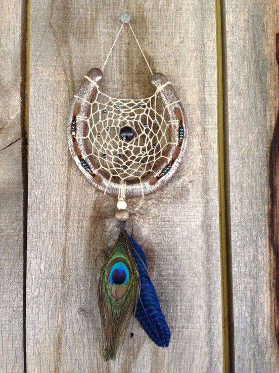 horseshoe shapeed dreamcatcher with a peacock and blue feather