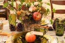 rustic table decor with a wooden log, apples and fresh flowers