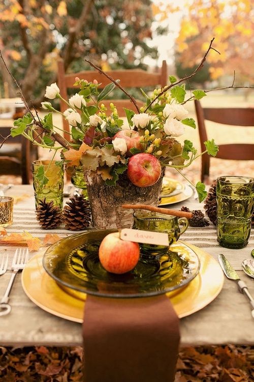 rustic table decor with a wooden log, apples and fresh flowers