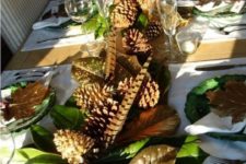 rustic table with feathers, pinecones, green leaves