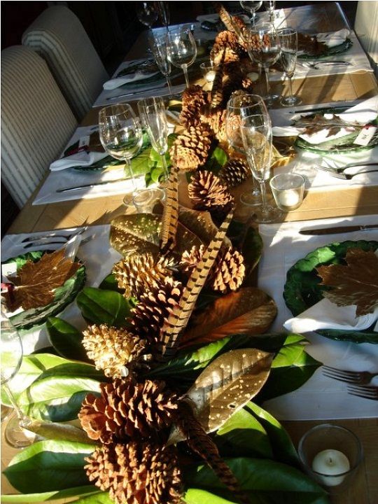 rustic table with feathers, pinecones, green leaves