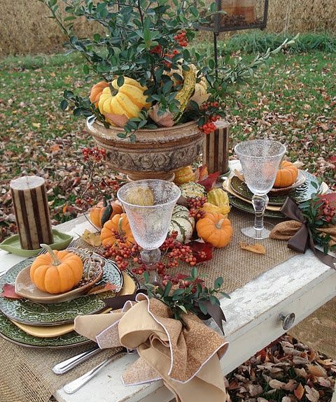 rustic tablescape with pumpkins, gourds and berries and a burlap tablecloth