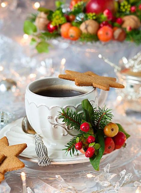 a cup with a gingerbread cookie, evergreens and holly berries