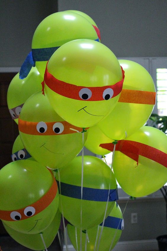 green balloons with eyes and headbnads made of paper