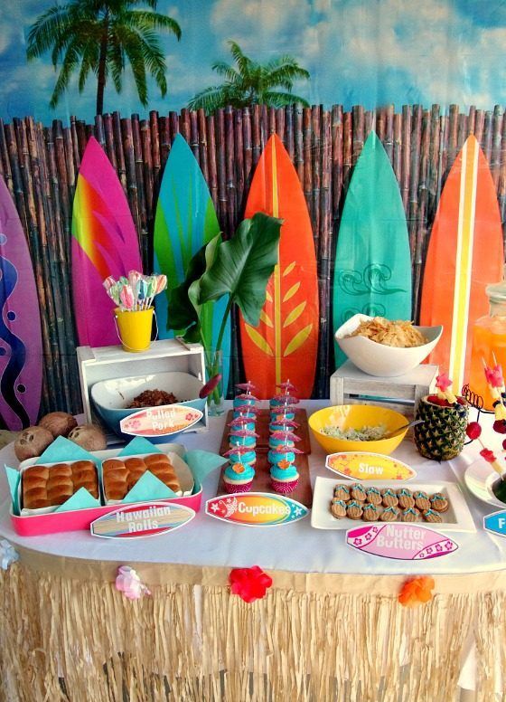 colorful dessert table with a surf boards backdrop