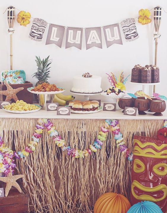 luau dessert table decorated with Hawaiian items and paper flowers