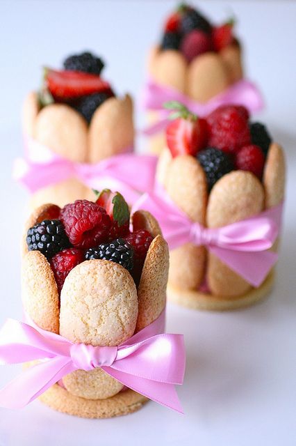 lady fingers, filled with mousse, topped with fresh berries and tied with a bow