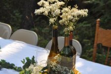 24 wine bottles tied together with burlap and sunflowers for a rustic centerpiece