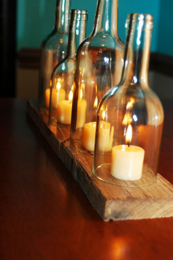 cut wine bottles used as cloches for candles and a wooden board to hold them all