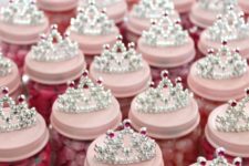 26 pink candies in jars as party favors topped with tiaras