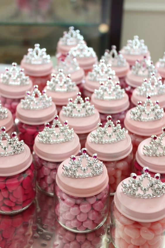 pink candies in jars as party favors topped with tiaras