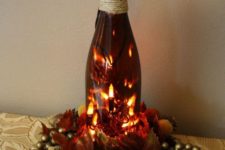 27 festive wine bottle centerpiece with LEDs and gilded decorations
