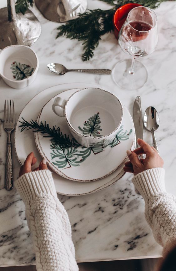 a Christmas tablescape with printed porcelain, glasses, evergreens and candleholders is simple and cute