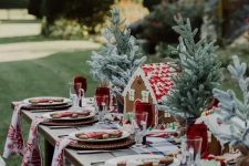 a bold and cool Christmas table setting with a plaid runner and printed napkins, tabletop Christmas trees, gingerbread houses and men