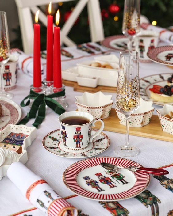 a bright Christmas tablescape with printed porcelain, red candles, star shaped bowls and printed textiles
